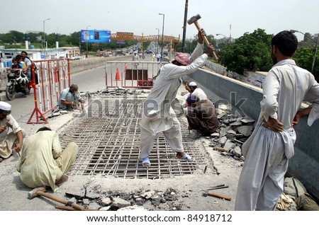 KARACHI, PAKISTAN - SEPT 17: Labors repair a broken portion of Rashid Minhas Flyover in Karachi on September 17, 2011.