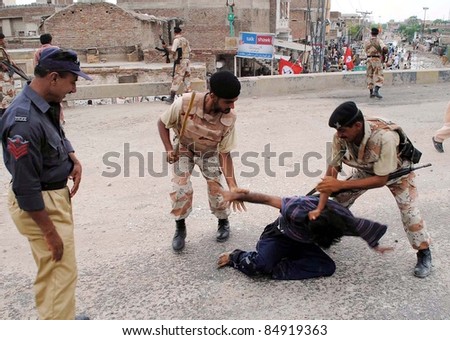 HYDERABAD, PAKISTAN - SEPT 17: Rangers soldiers arrest a protester during protest demonstration of Jeay Sindh Qaumi Mahaz (JSQM) against arrest  at Hyderabad Bypass on September 17, 2011 in Hyderabad .