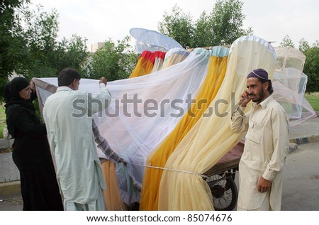 KARACHI, PAKISTAN - SEPT 20: People buy mosquito nets at a push-cart as demand of mosquito nets increased in city due to the Fear of Dengue Virus September 20, 2011Karachi  .