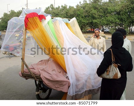 KARACHI, PAKISTAN - SEPT 20: People buy mosquito nets at a push-cart as demand of mosquito nets increased in city due to the Fear of Dengue Virus on September 20, 2011Karachi.
