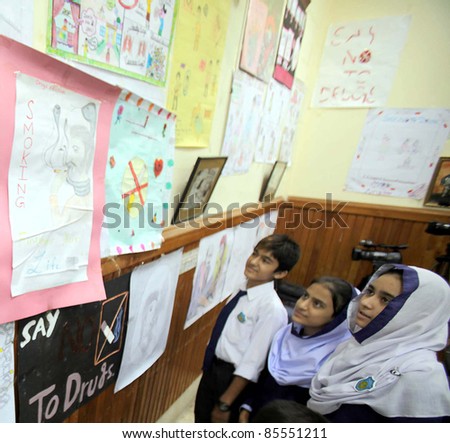 PESHAWAR, PAKISTAN - SEPT 28: Schoolchildren look paintings during an exhibition arranged by Anti-Narcotics Force held on September 28, 2011 in Peshawar.