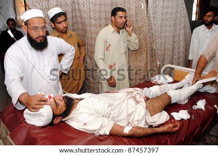 PESHAWAR, PAKISTAN - OCT 26: People gather near an injured man who was injured in an explosion, at Lady Reading hospital (LRH) on October 26, 2011in Peshawar.