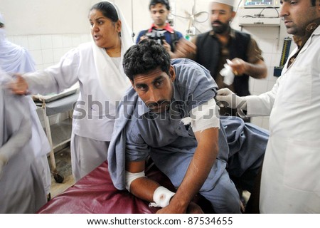 PESHAWAR, PAKISTAN - OCT 27: Paramedic staff gives treatment to an injured man, who was injured in explosion at Rampura Bazaar, being shifted  Lady Reading hospital  on October 27, 2011 in Peshawar.