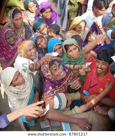 HYDERABAD, PAKISTAN - OCT 31: People, who were displaced and affected by recent rain and flood, gather to get food while volunteers distribute food of one month among them on October 31, 2011 in Hyderabad Pakistan.