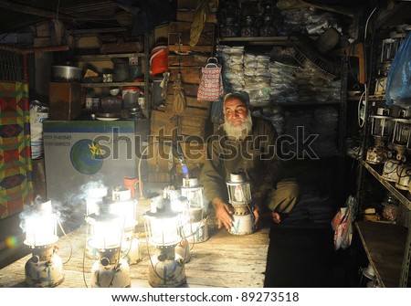 KARACHI, PAKISTAN - NOV 21: A shopkeeper prepares lanterns for rent out during electricity load-shedding in a main commercial market of city in Karachi on November 21, 2011.