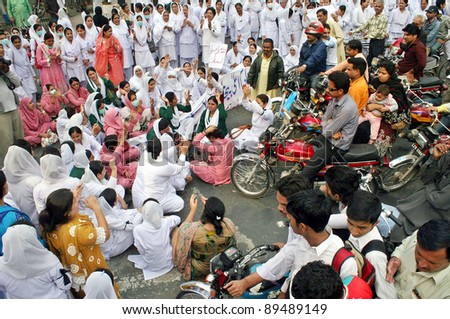 LAHORE, PAKISTAN - NOV 24: Angry protesters stop motorists to move forward during protest demonstration of Young Nurses Association (YNA) in favor of their demands on November 24, 2011in Lahore, Pakistan.