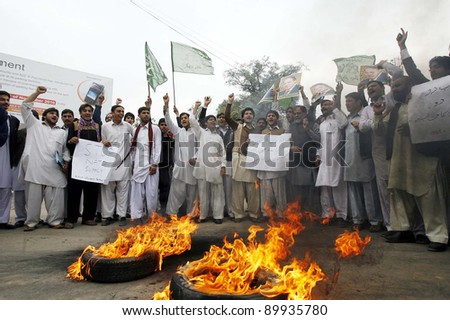 PESHAWAR, PAKISTAN - DEC 01: Supporters of Muslim League-N stand near burning tyres as they are protesting against NATO attack in the Country, on December 01, 2011in Peshawar.