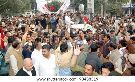 GUJRANWALA, PAKISTAN - DEC 08: Supporters of WAPDA Hydro Electric Central Labor Union pass through GT road during protest rally against privatization on December 08, 2011in Gujranwala.