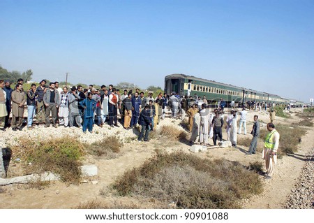HYDERABAD, PAKISTAN - DEC 15: Karakorum express passengers gather under the open sky while they are wait for another train engine as their train engine caught fire and burnt on Dec. 15, 2011 in Hyderabad, Pakistan.