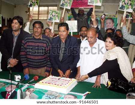 LAHORE, PAKISTAN, DEC 29: Activists of Muslim League-N cut cake during a ceremony to celebrate the birthday of Nawaz Sharif held in Lahore on Thursday, December 29, 2011.
