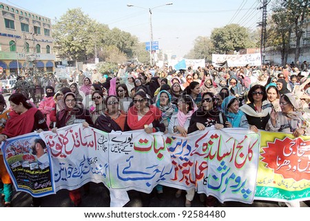LAHORE, PAKISTAN - JAN 12: Supporters of Punjab Professors and Lecturers Association pass through a road during protest rally in favor of their demands on January 12, 2012  in Lahore.