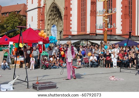 WUERZBERG, GERMANY - SEPT 11: People watch artist  at street-music festival on September 11, 2010 in Wuerzburg, Bavaria, Germany. The festival aids young musicians and artists.