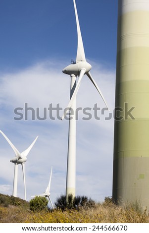vertical three wind turbine generators in windy valley