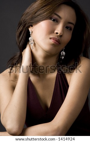 A beautiful asian woman with her hand behind her neck