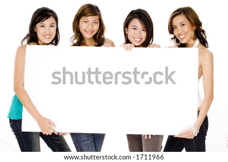 Four attractive young asian women holding a blank sign board