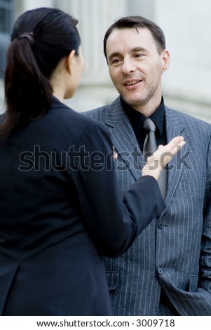 A businessman and woman talking outside