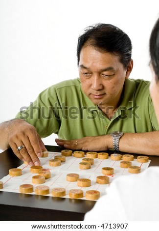 Two Chinese men in their fifties playing chess in the studio