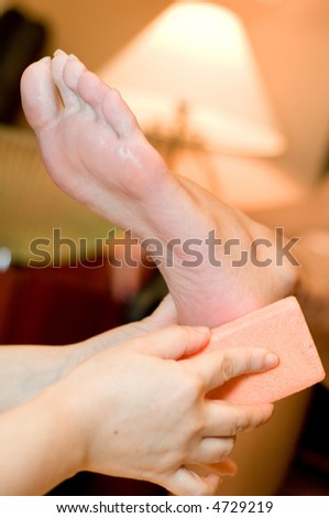 A young woman having her foot scrubbed in beauty salon