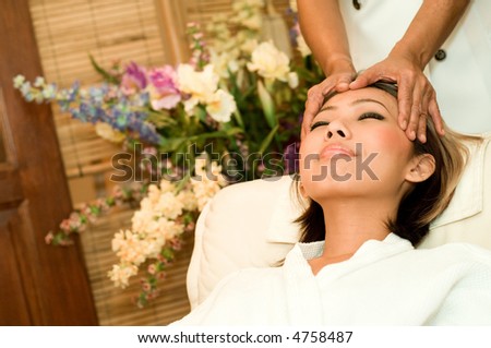 A young Asian woman having a head massage in a beauty salon