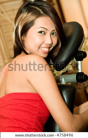 A young Asian woman sitting in a massage chair in a salon