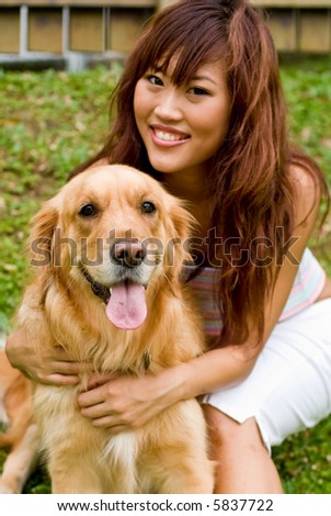 A pretty asian women outside with a dog