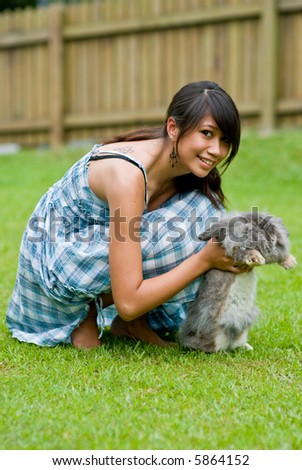Pretty asian woman outside with pet rabbit