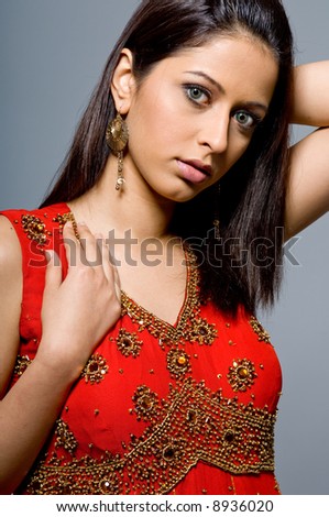 A beautiful young woman in sari on grey background