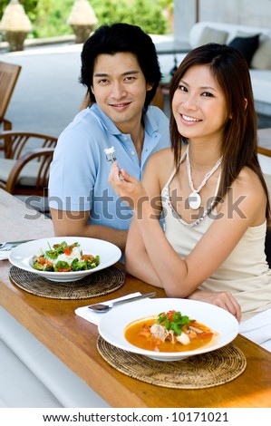 A young attractive couple eating Thai food