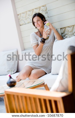 A young woman sitting with a tropical drink on vacation