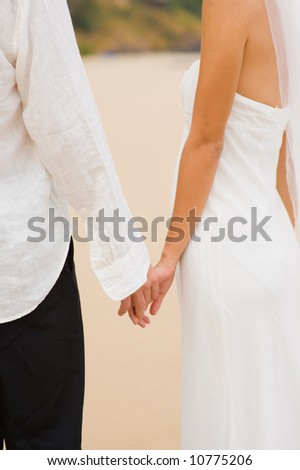 couple holding hands on beach. young couple holding hands