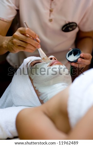 A young woman has a facial treatment at a spa