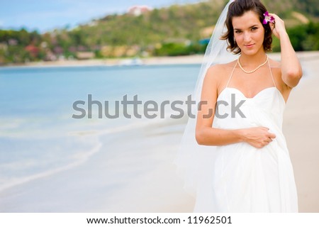 A young bride in wedding dress on a tropical beach