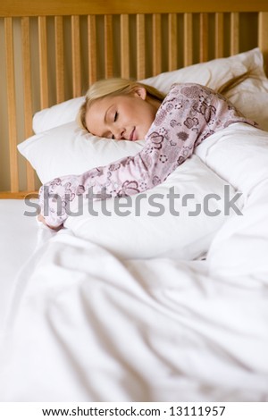 A young woman in pyjamas asleep in bed