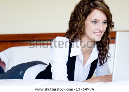 A young businesswoman back at home lying on bed with laptop