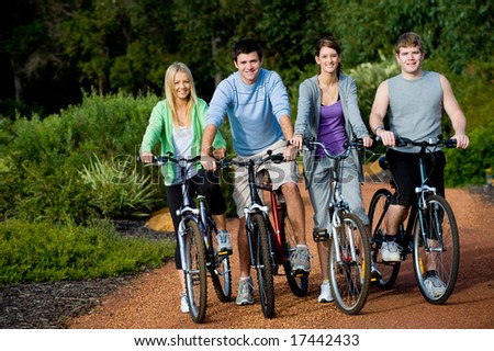 A group of four adults on bicycles in the countryside