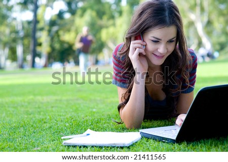 A young attractive woman studying  outside