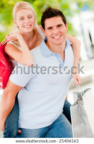 A young attractive couple together outside with shopping bags
