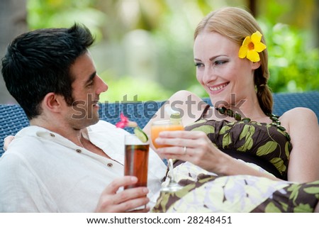 An attractive couple having drinks outside on vacation