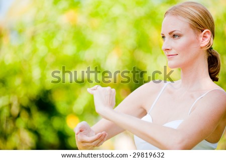 A slim tall woman doing tai chi outside