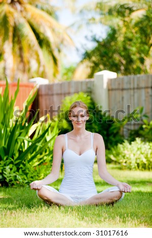 A young attractive woman sitting outside looking calm and relaxed