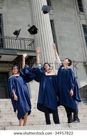 A group of graduates toss their mortar boards into the air