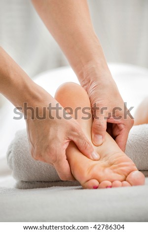 A foot massage being carried out in a spa by a masseuse