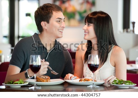 A young and attractive couple dining together in an indoor restaurant