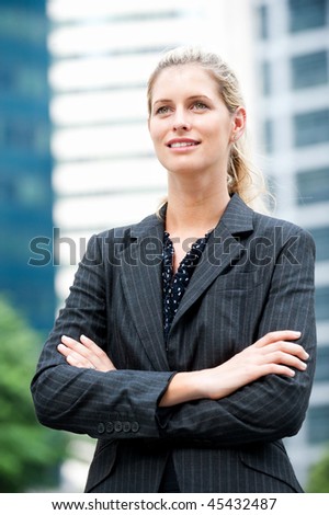 A young and attractive businesswoman standing confidently in an urban setting