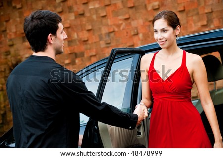 An attractive well-dressed lady stepping out of a stylish car outdoors