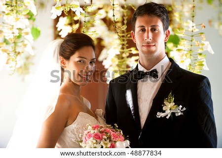 An attractive bride and groom getting married outdoors