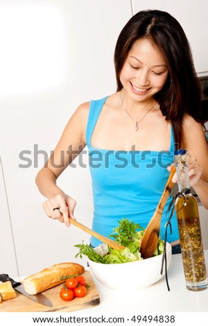 A good looking woman preparing a healthy meal of bread and salad in her kitchen at home