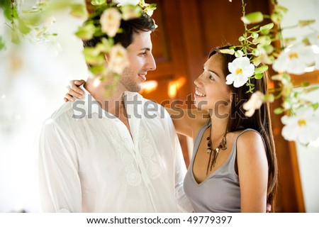 An attractive young couple gazing at each other outdoors