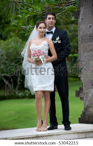 Attractive caucasian newly weds getting married outdoors in a garden