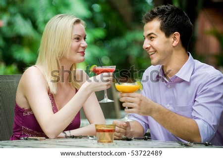 An attractive caucasian couple having drinks and relaxing at an outdoor restaurant